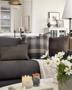 a living room filled with lots of furniture and flowers on top of a coffee table