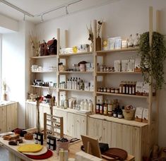 a room filled with lots of wooden shelves covered in bottles and containers next to a window