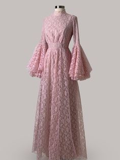 a pink dress on a mannequin with long sleeves and ruffled hems