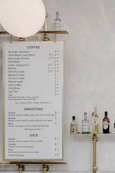 a menu on a wall next to bottles of liquor and a lamp in a room