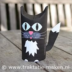 a black cat made out of paper sitting on top of a wooden table