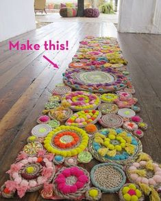 a long row of crocheted rugs sitting on top of a wooden floor