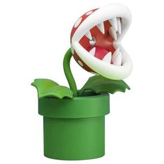 a green pot with a red and white object in the shape of a monster's mouth