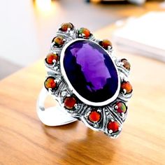 Elevate your jewelry collection with our stunning Vintage 5.00 Carat Vivid Purple Lab-Created Amethyst Filigree Ring. This enchanting piece features a breathtaking deep purple amethyst that captures the light beautifully, exuding elegance and allure. Set in intricate filigree detailing, the ring is crafted from high-quality 925 Solid Sterling Silver, stamped for authenticity. The addition of radiant red lab-created fire opal accent stones adds a delightful pop of color, creating a harmonious contrast that makes this ring a true statement piece.The vintage design makes it perfect for both everyday wear and special occasions, ensuring you'll turn heads no matter where you go.  To maintain the beauty of your ring, we recommend keeping it away from harsh chemicals and storing it in a soft pouc Amethyst Multi-stone Ring Gift, Oval Multi-stone Amethyst Ring Gift, Classic Silver Amethyst Ring With Multi-stone, Classic Multi-stone Amethyst Ring Gift, Silver Ruby Cabochon Ring, Silver Amethyst Ring Collectible, Silver Multi-stone Ruby Ring As Gift, Silver Amethyst Collectible Ring, Silver Amethyst Cabochon Ring For Anniversary