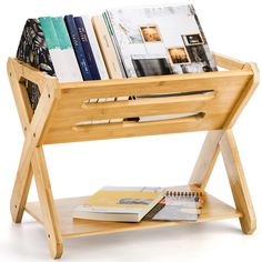 a wooden book stand with books on it and a notebook in the bottom shelf next to it