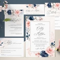 the wedding stationery is laid out on top of each other, with pink and blue flowers