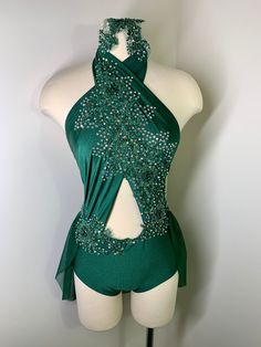 a female mannequin wearing a green dress with sequins on the back