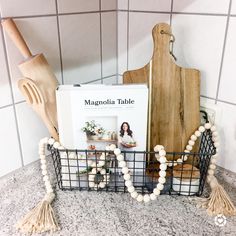 a cookbook sits on top of a wire basket with tassels