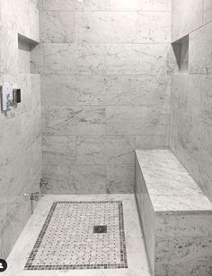 a walk in shower sitting next to a tiled floor