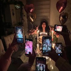 a group of people holding up cell phones with candles in the shape of hearts on them