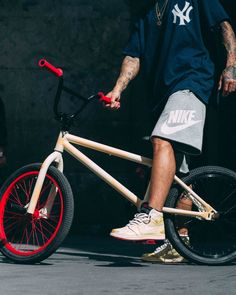 a man riding a wooden bike with red spokes on the front and back wheels