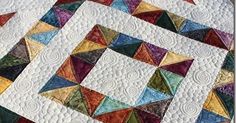 a quilted table topper with colorful squares on it