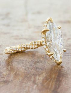 an oval shaped diamond ring on top of a wooden table