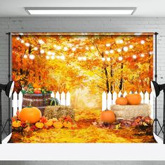 an autumn scene with pumpkins and hay bales in front of a brick wall