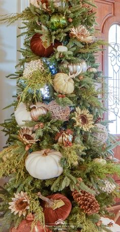 a christmas tree decorated with pumpkins and pine cones