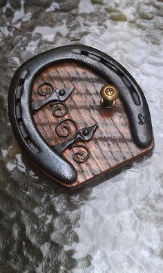 a clock made out of wood and metal with scissors on it's face, sitting on some ice