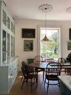 a dining room table and chairs in front of a window