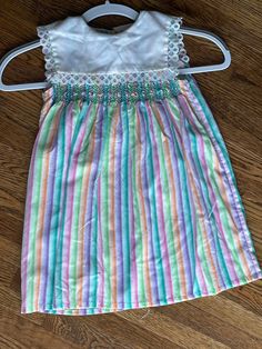 This vintage girls dress is smocked with a sailor like collar.  The closure is in the back with buttons.  The chest measurement is 26 inches and the length from shoulder seam to hem is 21.5 inches long. The stripes are orange, pink, lavender, and green with a white collar trimmed in lace. To see more of the variety of clothing we carry please visit my store at ChoiceRecycling.  We have a variety of recycled items with more to come soon. Thank you, Karmyn Vintage Smocked Summer Dress, Striped Lined Sundress, Vintage Smocked Bodice Summer Dress, Striped Sundress With Lining, Spring Striped Smocked Dress With Smocked Bodice, Striped Smocked Dress For Summer, Spring Striped Smocked Dress, Vintage Cotton Smocked Dress With Smocked Back, Vintage Cotton Dress With Smocked Back