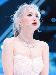 a woman in a white top and some necklaces