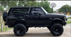 a large black truck parked on top of a driveway