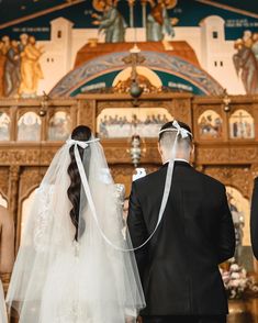 a bride and groom standing in front of the alter at their wedding ceremony, looking back