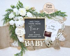 a baby announcement with teddy bears, flowers and other items on the table next to it