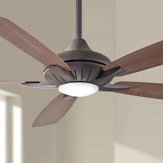 a ceiling fan with two wooden blades and a light on it's side, in a living room