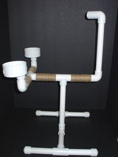 there is a toilet paper dispenser made out of pipes and pipe holders