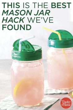 two mason jars filled with pink lemonade and topped with green lids, sitting next to each other