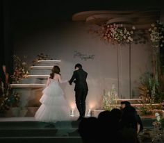 a bride and groom are walking down the aisle at their wedding ceremony in front of an audience