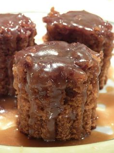 three pieces of chocolate cake sitting on top of a white and yellow plate with caramel drizzle