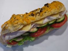 a sandwich with cheese, lettuce and tomatoes