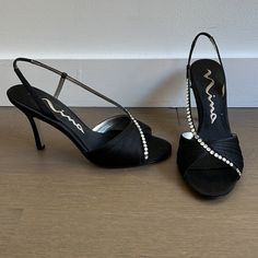 Like New And Worn Once For A Few Hours. Comes With Original Packaging And Pink Dust Bag That Was Never Used. These Beautiful Black Strappy Satin Finish Heels Are Absolutely Stunning . There’s Also A Tiny Elastic On The Ankle And I Think It’s Awesome Because My Foot Never Fell Out Of The Shoe. There Are No Flaws Other Than Sign Of Use On The Soles And 2 Missing Rhinestones. However, There Are 4 Extra Rhinestones To Replace Them. Heel Height: 3.5” Chic Evening Heels With Silver Accents, Elegant Evening Heels With Silver Accents, Elegant Silver Heels For Dinner, Black Heels With Silver Accents For Evening, Dress Heels, Nina Shoes, Dress And Heels, Satin Finish, Shoes Women Heels