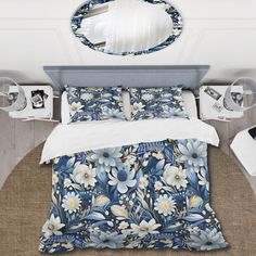 a bed with blue flowers on it and a round mirror above the bedspread