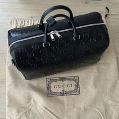 Brand New Authentic Gucci Travel Tote Back, Fully Leather With Embossed Gg Letters. Comes With Dust Bag And Strap. Please No Low Offers, I Will Not Entertain Them. Via Gucci Website :Style 725282 1w3cn 1000 Classic Travel Accessories Are Reimagined In New Dimensions As Part Of The Latest Collection. Gg Leather Combines Softness With The Embossed Allover House Emblem, Playing On Texture And Resulting In A Slightly Shiny Finish. This Duffle Bag Appears In A Black Variation Of The Emblematic Materi Gucci Business Bag With Logo, Designer Bag With Logo For Everyday Luxury, Designer Everyday Luxury Bag With Logo, Black Gucci Bag With Logo, Luxury Business Bag With Logo, Black Rectangular Bag With Designer Logo, Black Designer Gucci Bag, Black Designer Logo Bag For Everyday Use, Black Designer Logo Bag For Everyday