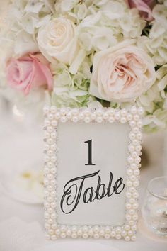 an image of a table number with flowers in the background and text that reads 1 table