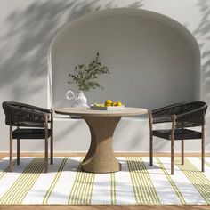 a table with two chairs and a vase on it in front of an arched wall