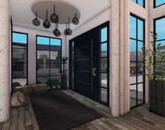 a living room filled with lots of windows and furniture next to a black front door