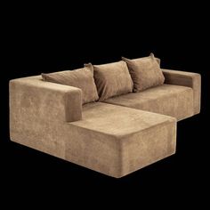 a brown couch with pillows on it in front of a black background or wallpaper