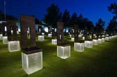 illuminated chairs in the grass at night with trees in the background and lights shining on them