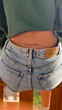 a woman's stomach with the word competia written on her lower back