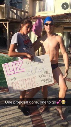 two people standing next to each other holding a sign