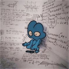 a blue cartoon character sitting on top of a white wall covered in lots of writing