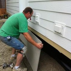 a man working on the side of a house