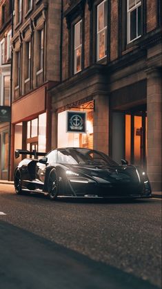 a black sports car parked in front of a building on the side of a street