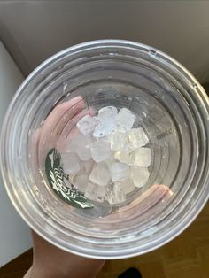 a person holding a cup filled with ice cubes