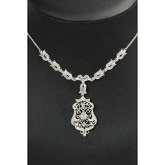 Delicate diamond 14k white gold necklace featuring a floral and scroll filagree design drop pendant necklace.  The back part of the chain is a weave pattern and the front near the pendant has six diamond tulip like flowers with a centralized diamond bow.  From the diamond bow hangs another diamond tulip which leads to the open foliage drop pendant.  If you look closely, you can see a small heart above the center leaf in the pendant.  Marked Italy 585(for 14K) Elegant Oval Filigree Necklace, Elegant Engraved Diamond Necklace, Elegant Engraved Cubic Zirconia Jewelry, Elegant Sterling Silver Engraved Diamond Necklace, Elegant Engraved Sterling Silver Diamond Necklace, Refined Silver Diamond Necklace For Formal Occasions, Elegant Engraved Necklaces For Evening, Oval Diamond Filigree Necklace, Elegant White Gold Teardrop Pendant Diamond Necklace