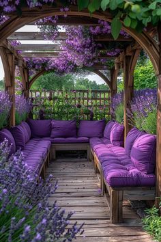 an outdoor seating area with purple couches and lavender flowers on the pergoline