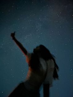 a woman reaching up into the sky with her arms in the air and stars above