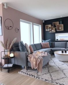 a living room filled with lots of furniture next to a large white rug on top of a hard wood floor